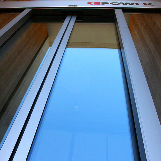 Gewerbebau Bever | Detail Verglasung mit Eingangsautomat in Inoxlook
